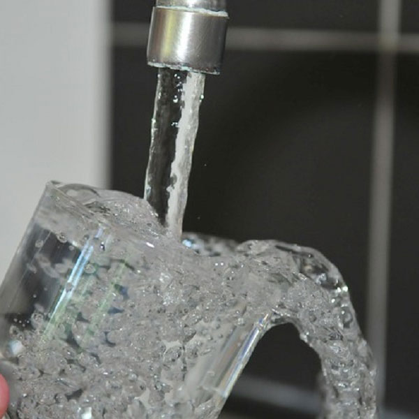 Water faucet that uses Fleck Iron Pro 2 with a glass of water for drinking