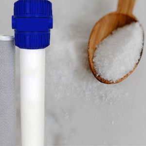 Water softener cartridge with salt and a wooden spoon full of salt