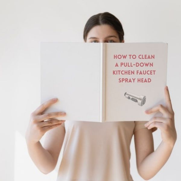 A woman holding a manual with a title how to clean a pull-down kitchen faucet spray head