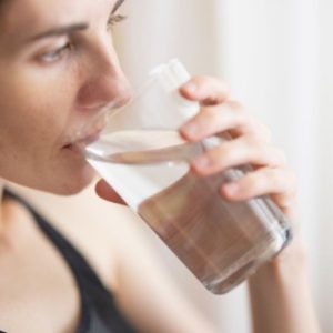 Woman drinking a glass of soft water