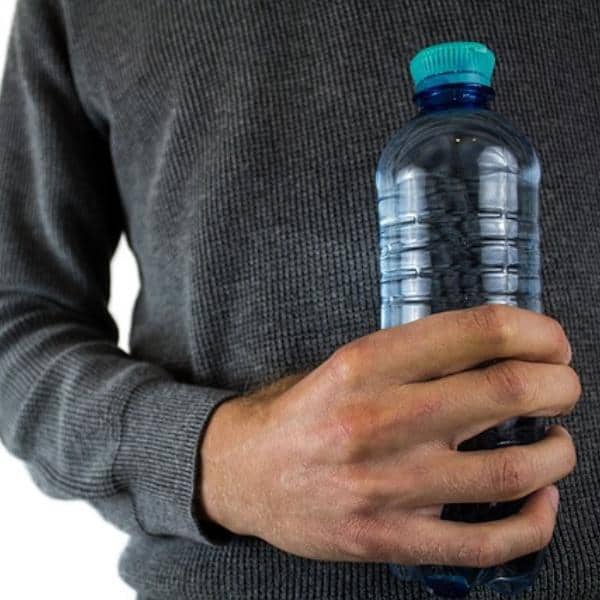 person holding a bottle of distilled water